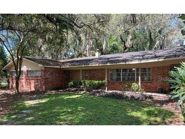 Charming single story brick home with front porch and manicured lawn at 11002 Ridgedale Rd, Temple Terrace, FL 33617