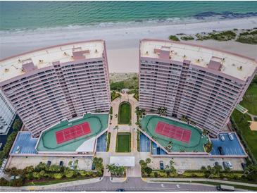 Stunning aerial view of beachfront condo buildings with private tennis courts and beautifully landscaped grounds at 1340 Gulf Blvd # 16A, Clearwater Beach, FL 33767