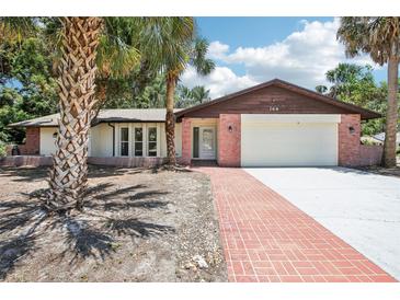 Charming single-Gathering home featuring a brick pathway, two-car garage, and well-maintained landscaping at 166 11Th N Ave, Safety Harbor, FL 34695
