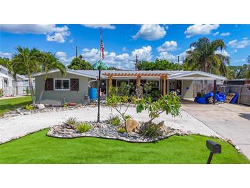 Charming home featuring a landscaped front yard, unique rock features, and a welcoming trellis entrance at 2912 Case Ave, Bradenton, FL 34207