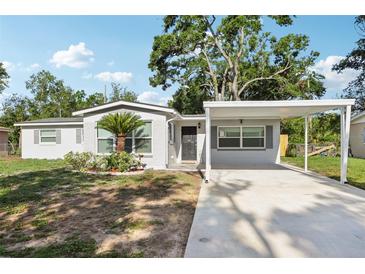 Charming single-story home featuring a carport and a well-maintained front yard at 7110 Bonito St, Tampa, FL 33617