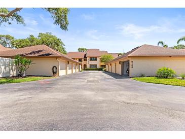 Well-maintained exterior of townhomes with individual garages in a quiet residential community, under a blue sky at 8103 Bardmoor Pl # 203G, Seminole, FL 33777