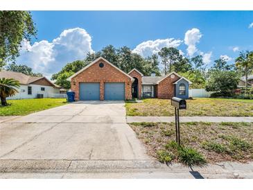 Charming single-Gathering home with a brick facade, two-car garage, and a well-maintained front yard at 1024 Dockside Dr, Lutz, FL 33559