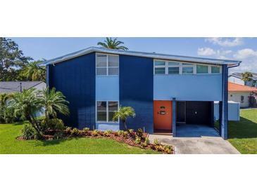 Modern two-story home showcasing a colorful exterior, a manicured lawn, and vibrant landscaping at 111 Chesapeake Ave, Tampa, FL 33606