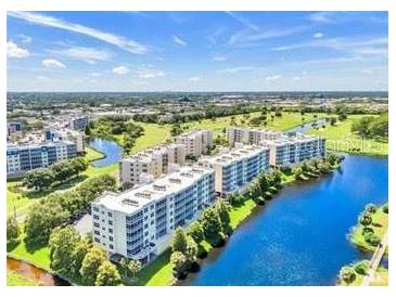 Scenic aerial view of multi-story condominium buildings with beautiful lakes and greenery in a desirable community at 1200 Country Club Dr # 6302, Largo, FL 33771
