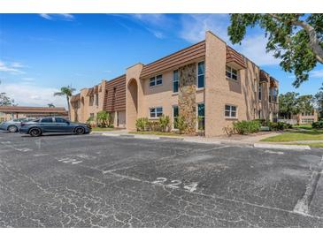 Exterior of a charming two-story condo building showing parking, landscaping and stone details at 224 Aspen Cir # 224, Seminole, FL 33777