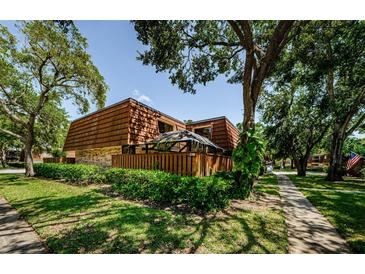 Exterior view of a townhome with a well-kept lawn, a fence and beautiful trees at 2706 11Th Ct, Palm Harbor, FL 34684
