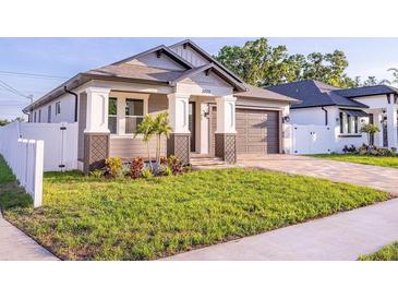 Charming single-story home featuring a well-manicured lawn and a private driveway leading to an attached garage at 3002 W Abdella St, Tampa, FL 33607