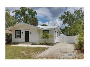 Charming home with a well-maintained lawn and gravel driveway at 3008 E 38Th Ave, Tampa, FL 33610