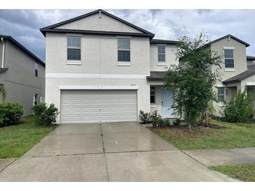 Two-story home featuring a two-car garage, light blue front door and manicured landscaping at 3810 Romano Busciglio St, Tampa, FL 33619