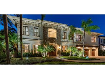 Elegant two-story home featuring lush landscaping and an inviting stone facade with beautiful architectural details at 4313 W Beachway Dr, Tampa, FL 33609