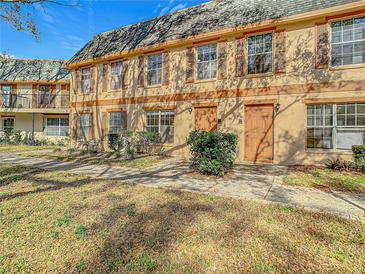 Charming two-story townhome with tan exterior, brown trim, shutters and well maintained landscaping at 4405 Vieux Carre Cir # 4405, Tampa, FL 33613