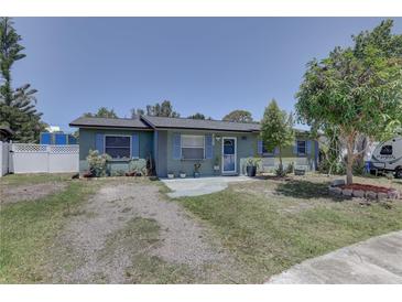 Charming single-story home with blue shutters, lush landscaping, and mature trees in a quiet neighborhood at 9240 53Rd N Way, Pinellas Park, FL 33782