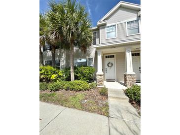 Charming townhome with manicured landscaping and inviting front entrance, enhanced by elegant stone accents and palm trees at 12334 Country White Cir, Tampa, FL 33635