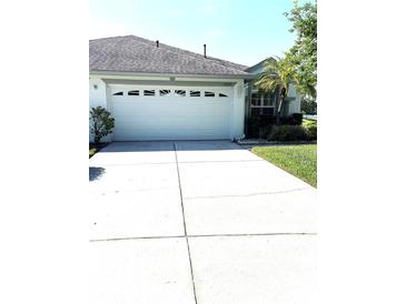 Charming home featuring a well-maintained two-car garage and extended driveway with manicured lawn at 19420 Haskell Pl, Land O Lakes, FL 34638