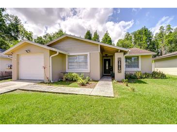 Charming single-story home with a well-manicured lawn and inviting front garden at 2818 Cedaridge Dr, Tampa, FL 33618