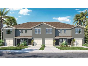 Charming townhome exterior with well-maintained landscaping, a private garage, and inviting front entrances at 31266 Midnight Sun Way, Wesley Chapel, FL 33545