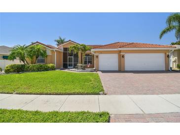 Charming single-story home with a red tile roof, lush landscaping, and a two-car garage at 3737 Gaviota Dr, Sun City Center, FL 33573