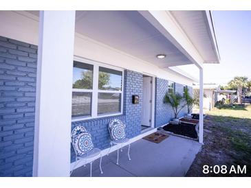 Inviting front porch featuring blue brick, white columns, and decorative chairs at 5608 Larimer Dr, Tampa, FL 33615