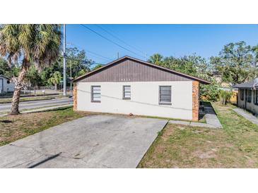 Front exterior view showing a driveway and a brown roof at 8317 N Marks St, Tampa, FL 33604