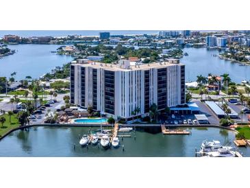Panoramic aerial view of a waterfront condo building with a pool, boat docks and stunning coastal scenery at 10355 Paradise Blvd # 502, Treasure Island, FL 33706
