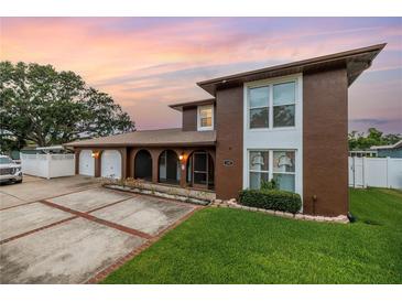 Charming two-story home boasts a well-manicured lawn, a three-car garage, and an inviting arched entryway at 1449 45Th Ne Ave, St Petersburg, FL 33703