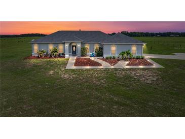 Charming single-story home featuring manicured landscaping and a well-maintained lawn at sunset at 30017 Johnston Rd, Dade City, FL 33523