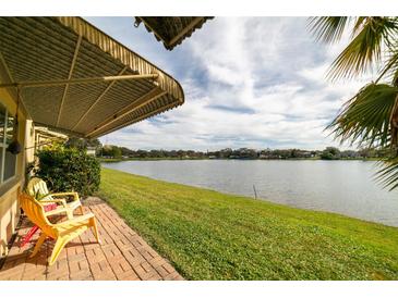 Outdoor patio with red brick and lawn views of the water and community landscape under an awning at 3850 13 N Ave # 113, St Petersburg, FL 33713