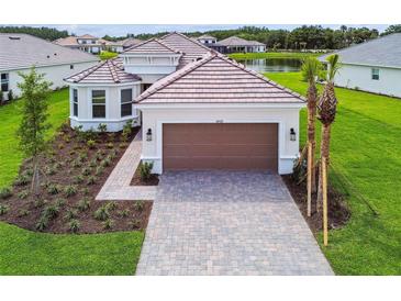 Stunning home with a clay tile roof, paver driveway, mature landscaping, and a lake view at 4709 Isonzo Way, Wesley Chapel, FL 33543