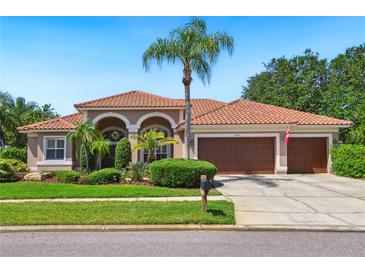 Charming single-story home with a clay tile roof and a well-manicured front lawn at 9912 Chris Craft Ct, Tampa, FL 33615