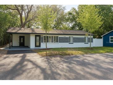 Charming single-story home with well-maintained lawn, carport, and brick accents near the front entry at 10406 N Boulevard, Tampa, FL 33612