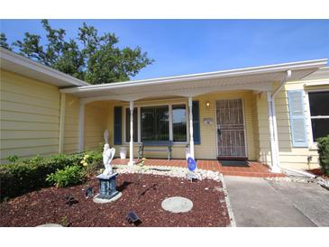 Inviting front porch area featuring brick flooring, decorative angel statue and blue shutters at 1444 Eastfield Dr, Clearwater, FL 33764