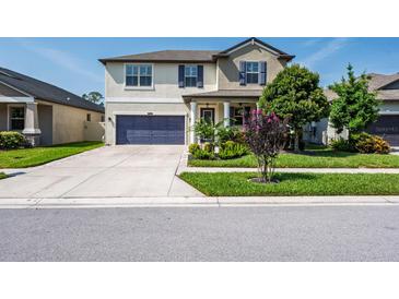 Charming two-story home with well-manicured lawn, lovely landscaping, and a welcoming front porch at 21874 Crest Meadow Dr, Land O Lakes, FL 34637