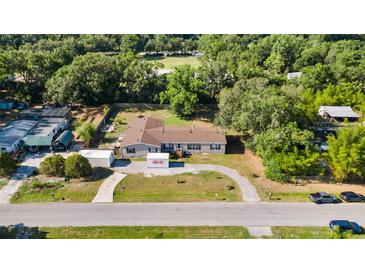 An aerial shot of a quaint home with a long driveway surrounded by mature trees and lush landscaping at 26438 Glenwood Dr, Wesley Chapel, FL 33544