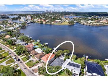 Waterfront property featuring a private dock and lush tropical landscaping on a serene bay at 3800 Shore Acres Ne Blvd, St Petersburg, FL 33703