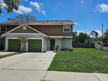 Charming townhome featuring an attached two-car garage and a well-maintained front lawn at 5101 Corvette Dr, Tampa, FL 33624