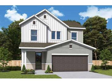 Charming two-story home with white siding, gray accents, a front porch, and a two-car garage at 5717 Spivey Ct, Wesley Chapel, FL 33545
