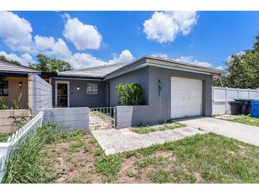 Cozy one-story home showcasing a charming gray exterior, a single-car garage, and a quaint, gated front yard at 702 Regent S Cir, Brandon, FL 33511