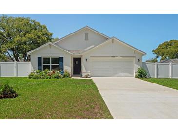 Charming single-story home featuring a well-manicured lawn, white exterior, and a two-car garage at 8508 Bay Dr, Spring Hill, FL 34606