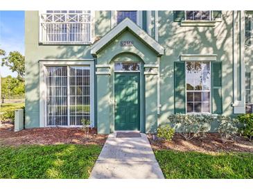 Inviting front entrance with green door, lush landscaping, and well-maintained walkway leading up to the home at 9416 Lake Chase Island Way # 9416, Tampa, FL 33626
