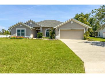 Charming one-story home with a lush green lawn and two car garage at 3095 Coronet Ct, Spring Hill, FL 34609