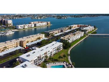 Breathtaking aerial view of waterfront condos with a community pool and boat docks, nestled amidst beautiful waterways at 7465 Bay Island S Dr # 213, South Pasadena, FL 33707
