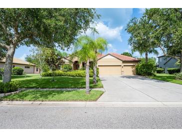 Charming single-story home featuring a three car garage, tile roof, and manicured front lawn at 9313 Lisbon St, Seffner, FL 33584