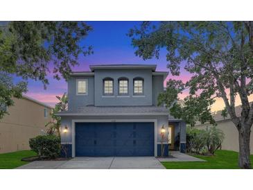 Charming two-story home with a blue two-car garage and well-maintained front yard and landscaping at 11121 Running Pine Dr, Riverview, FL 33569