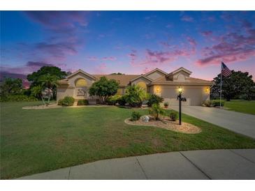 Charming single-story home with a well-manicured lawn and a tile roof at dusk at 1201 Peridot Ln, Sun City Center, FL 33573