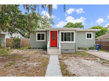 Charming home featuring a bright red front door and inviting curb appeal at 1408 Michigan Ave, Palm Harbor, FL 34683