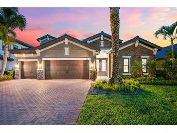 Beautiful single-story home featuring a three-car garage, well-manicured lawn, and tasteful stone and stucco accents at 1416 Via Verdi Dr, Palm Harbor, FL 34683