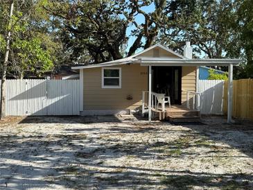 Tan home with white picket fence and partial covered porch with room to add personal touches at 3762 18Th S Ter, St Petersburg, FL 33711