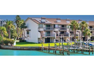 Waterfront condo featuring a private dock, balconies, and lush landscaping, perfect for enjoying coastal living at 101 Marina Del Rey Ct, Clearwater, FL 33767