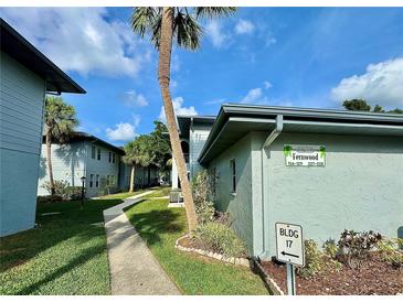 Well-maintained building exterior with lush landscaping and mature palm trees at 10800 Us Highway 19 N # 127, Pinellas Park, FL 33782